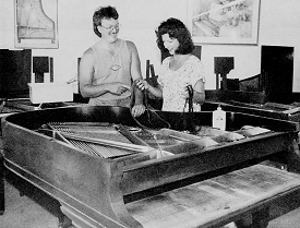 Mike and Lisa discussing the workings of a grand piano.